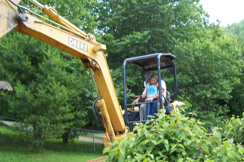 Mini excavator working on a planted garden slope