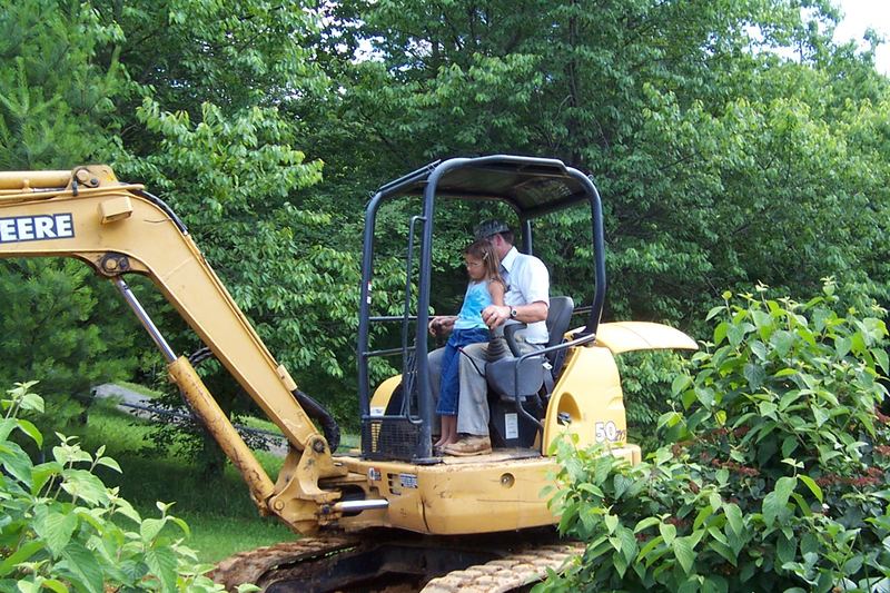 Mini excavator digging a septic trench in a garden